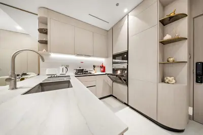 a large kitchen with white cabinets and a sink at Spacious 1BR in JVC with Lounge Access in Dubai