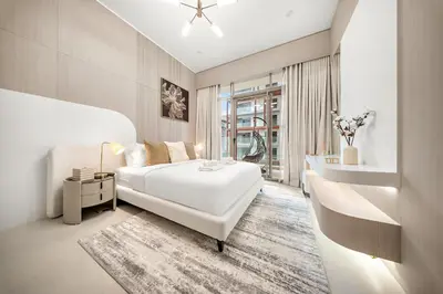 a white bedroom with a large bed and a window at Spacious 1BR in JVC with Lounge Access in Dubai