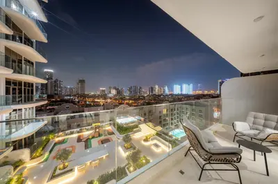 a balcony with a view of a city at night at Spacious 1BR in JVC with Lounge Access in Dubai