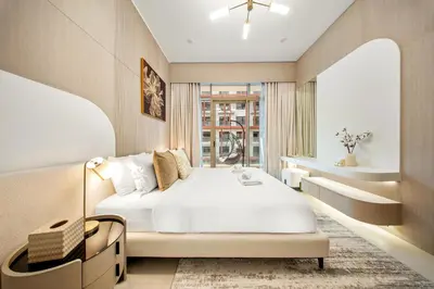 a bedroom with a large white bed and a window at Spacious 1BR in JVC with Pool and Gym Access in Dubai