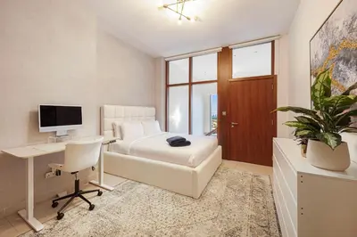a bedroom with a bed and a desk with a computer at Daniels 2BR Duplex at Central Park Tower, DIFC in Dubai