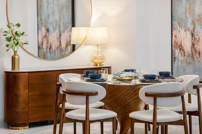 a dining room with a table with chairs and a mirror at Daniels 2BR Duplex at Central Park Tower, DIFC in Dubai