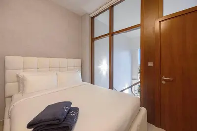 a bedroom with a bed with two towels on it at Daniels 2BR Duplex at Central Park Tower, DIFC in Dubai