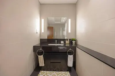 a bathroom with a sink and a mirror at Daniels 2BR Duplex at Central Park Tower, DIFC in Dubai