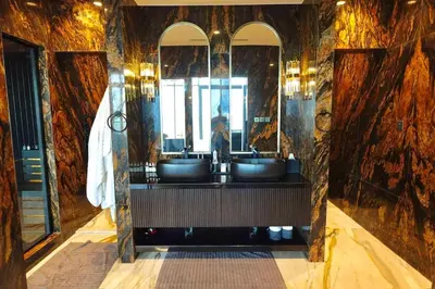 a bathroom with two sinks and two mirrors at Iconic Triplex Penthouse in Marina in Dubai
