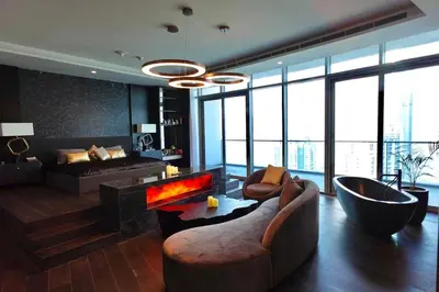 a living room with a couch and a fireplace at Iconic Triplex Penthouse in Marina in Dubai