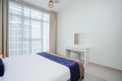 a white bedroom with a bed and a window at CitiHome - Spacious 2BR - Park Gate Residences in Dubai