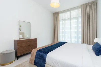 a bedroom with a bed and a mirror and a window at CitiHome - Spacious 2BR - Park Gate Residences in Dubai