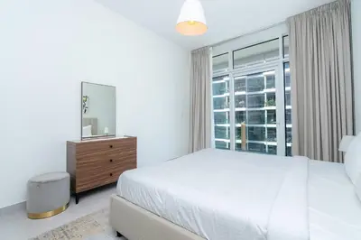 a bedroom with a white bed and a window at CitiHome - Spacious 2BR - Park Gate Residences in Dubai