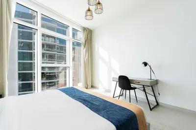 a bedroom with a bed and a desk and a window at CitiHome - Spacious 2BR - Park Gate Residences in Dubai