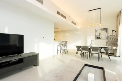 a living room with a tv and a table and chairs at CitiHome - Spacious 2BR - Park Gate Residences in Dubai