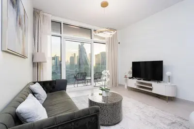 a living room with a couch and a tv at CitiHome - Spacious 1BR - Park Gate Residences in Dubai