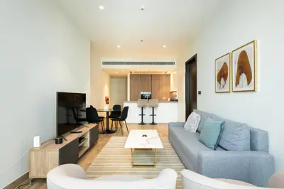 a living room with a blue couch and a table at CitiHome - Iconic 1BR Jumeirah Living Marina Gate in Dubai