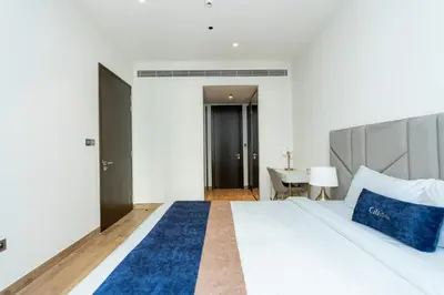 a bedroom with a bed with blue pillows and a desk at CitiHome - Iconic 1BR Jumeirah Living Marina Gate in Dubai