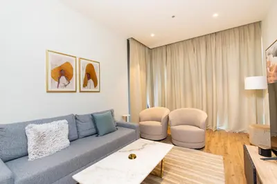 a living room with a blue couch and two chairs at CitiHome - Iconic 1BR Jumeirah Living Marina Gate in Dubai