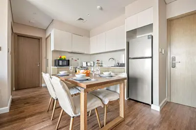 a kitchen with a table and chairs and a refrigerator at VayK -Downtown Dubai Chic 1BR Retreat in Dubai