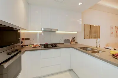 a kitchen with white cabinets and a sink at Luxury 2BR with Private Pool Balcony Arjan in Dubai