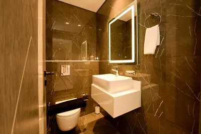 a bathroom with a sink and a toilet and a mirror at Luxury 2BR with Private Pool Balcony Arjan in Dubai