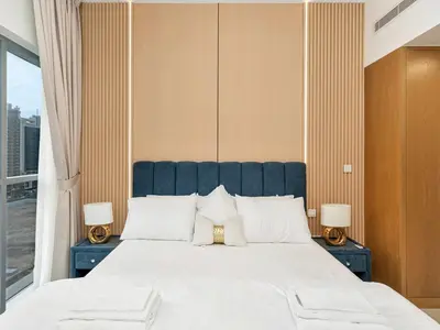 a bedroom with a large white bed with two lamps at Elegant 1BR in Bellevue Towers Downtown Dubai in Dubai