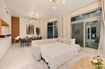 a living room with a white couch and a table at Luxury Apt in Lofts Downtown, Walk to Dubai Mall, Burj Khalifa, Gym, Pool, 500mbps Wifi in Dubai