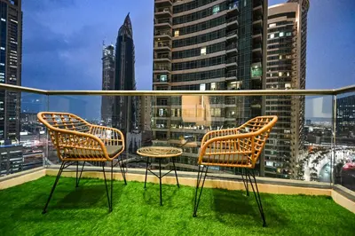 two chairs on a balcony with a view of a city at Luxury Apt in Lofts Downtown, Walk to Dubai Mall, Burj Khalifa, Gym, Pool, 500mbps Wifi in Dubai