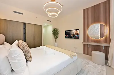 a bedroom with a large white bed and a tv at Luxury Apt in Lofts Downtown, Walk to Dubai Mall, Burj Khalifa, Gym, Pool, 500mbps Wifi in Dubai