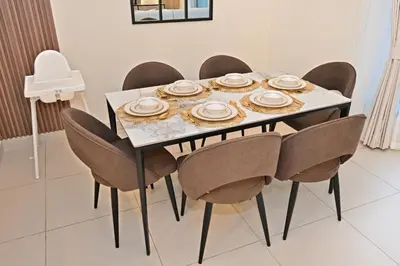 a dining room table and chairs with plates on it at Luxury Apt in Lofts Downtown, Walk to Dubai Mall, Burj Khalifa, Gym, Pool, 500mbps Wifi in Dubai