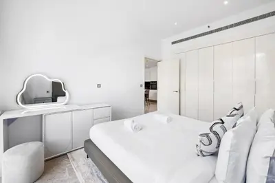 a white bedroom with a large bed and a tv at Stylish Apartment Business Bay Prime Location in Dubai