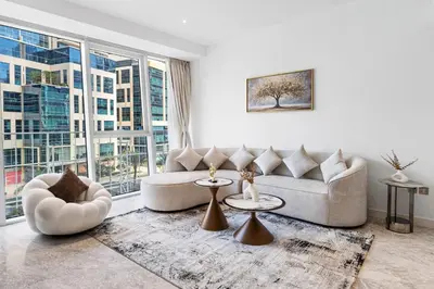 a living room with a couch and tables and windows at Stylish Apartment Business Bay Prime Location in Dubai