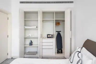 a bedroom with white cabinets and a bed at Stylish Apartment Business Bay Prime Location in Dubai