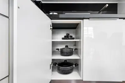 a kitchen with white cabinets with pots and pans at Stylish Apartment Business Bay Prime Location in Dubai