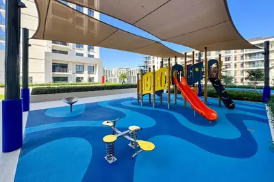 a play area with a playground with a slide at PVH - Chic Pool View 2BR Near Dubai Hills Park - Park Field Tower 2 in Dubai