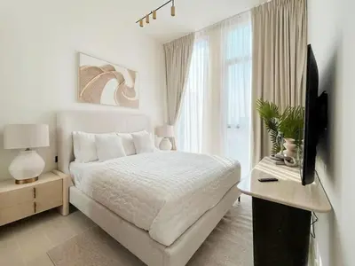 a white bedroom with a bed and a television at Dubai Premium 2BR with Private Pool and Balcony! in Dubai