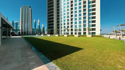 a large grassy area in a city with tall buildings at Stylish 4BR with Burj View and Dubai Mall Connection in Dubai
