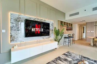 a living room with a tv on a wall at Stylish 4BR with Burj View and Dubai Mall Connection in Dubai