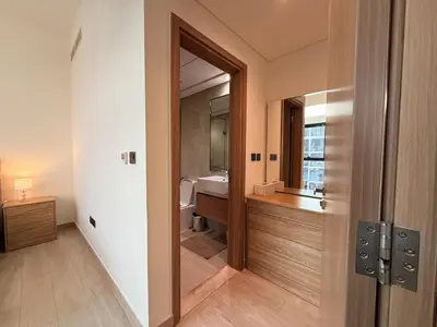a bathroom with a sink and a toilet and a mirror at Modern 2BR with Balcony in Azizi Riviera 23 in Dubai