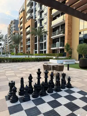 a chess board on a courtyard with a building at Modern 2BR with Balcony in Azizi Riviera 23 in Dubai
