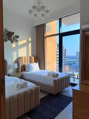 a hotel room with two beds and a large window at Modern 2BR with Balcony in Azizi Riviera 23 in Dubai