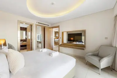 a bedroom with a bed and a chair and a television at Stylish 1-Bedroom Apartment at DAMAC Paramount in Dubai