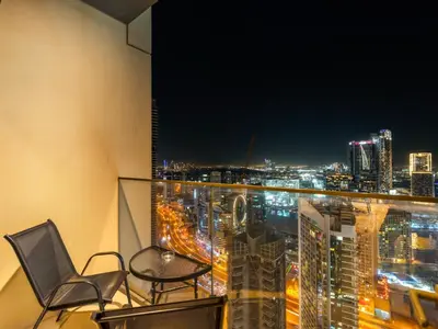 a balcony with two chairs and a view of a city at Burj Royale 1BD Apartment 5mins walk to Dubai Mall and Burj Khalifa in Dubai