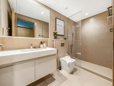 a bathroom with a toilet and a sink and a mirror at Burj Royale 1BD Apartment 5mins walk to Dubai Mall and Burj Khalifa in Dubai