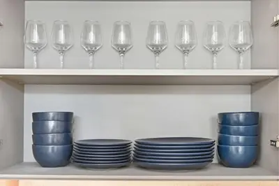 a row of wine glasses and plates on shelves at Incredible Family Townhouse Villa I Sleeps 10 in Dubai
