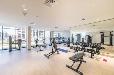 a gym with treadmills and cardio equipment in a building at Cozy 1BR, Easy Access to Dubai Mall - Azizi Riviera 36 by Deluxe Holiday Homes in Dubai