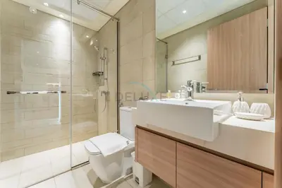 a bathroom with a toilet and a sink and a shower at Cozy 1BR, Easy Access to Dubai Mall - Azizi Riviera 36 by Deluxe Holiday Homes in Dubai