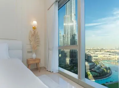a bedroom with a large window with a view of a city at Breathtaking 2Bedroom front-row Burj Khalifa & Fountain Views from Balcony, Grande Signature Residences in Dubai