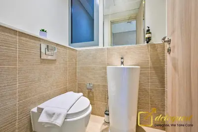 a bathroom with a white toilet and a sink at Luxury 2BR Dubai Hills Near Mall By Deleguest in Dubai