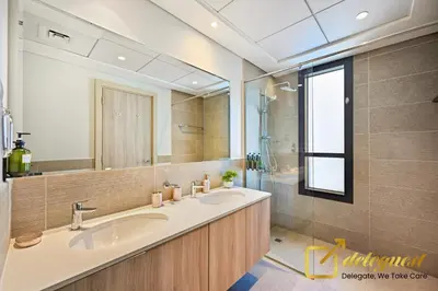 a bathroom with two sinks and a large mirror at Luxury 2BR Dubai Hills Near Mall By Deleguest in Dubai