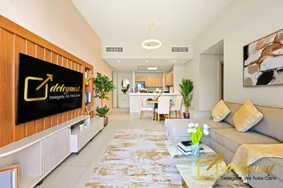 a living room with a couch and a tv at Luxury 2BR Dubai Hills Near Mall By Deleguest in Dubai