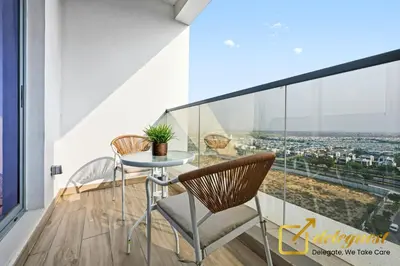 a table and two chairs on a balcony with a view at Luxury 2BR Dubai Hills Near Mall By Deleguest in Dubai