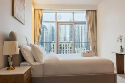 a bedroom with a bed and a large window at Iconic Burj Khalifa View - Elegant 1BR Apartment in Dubai